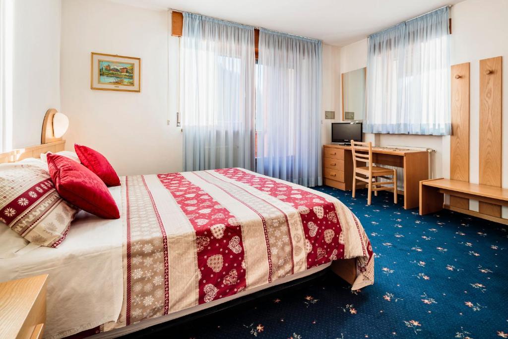 阿莱盖Hotel Coldai的配有一张床和一张书桌的酒店客房