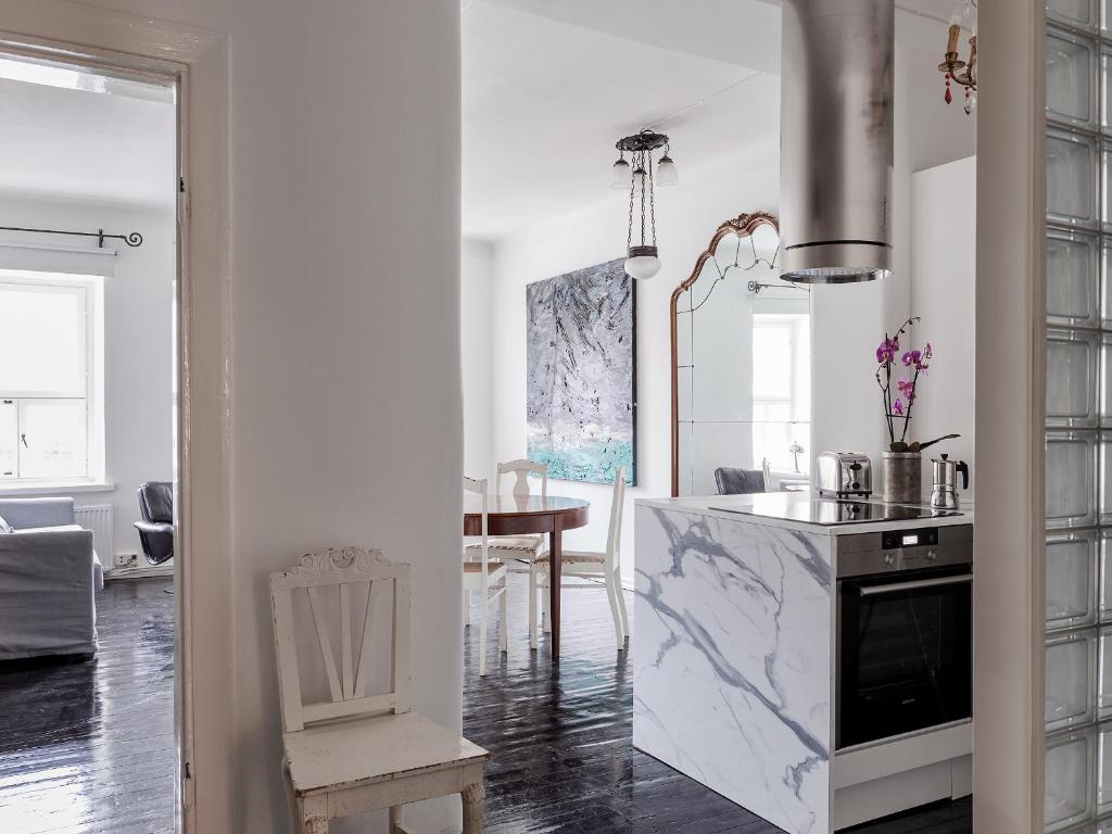赫尔辛基Artist Apartment Susi的厨房设有大理石台面和桌子
