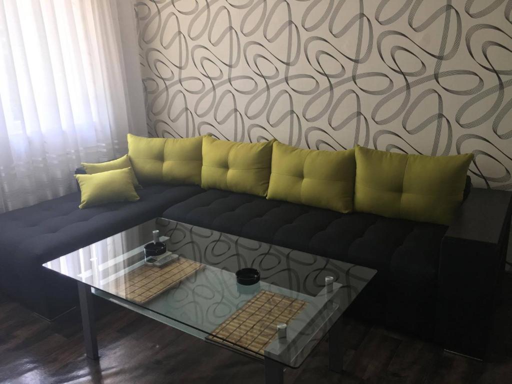 希萨里亚Apartment Bulgaria的一张带黄色枕头和桌子的黑色沙发