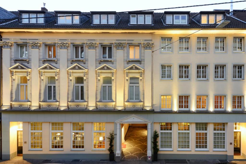 杜塞尔多夫Carlstadt Suites Düsseldorf的一座白色的大建筑,有许多窗户