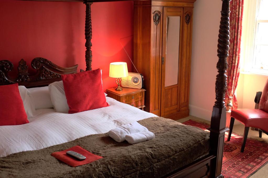 威特尼老庭院酒店的一间卧室设有一张带红色墙壁的大床