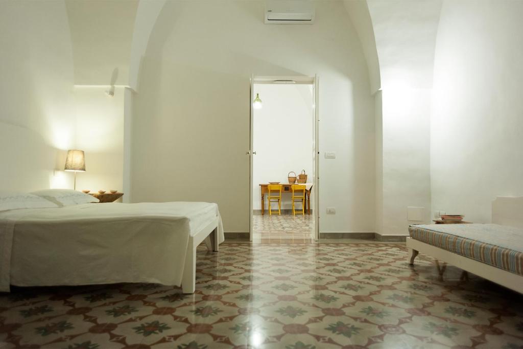 科尔萨诺Il Pergoletto的白色的客房配有两张床和一张桌子