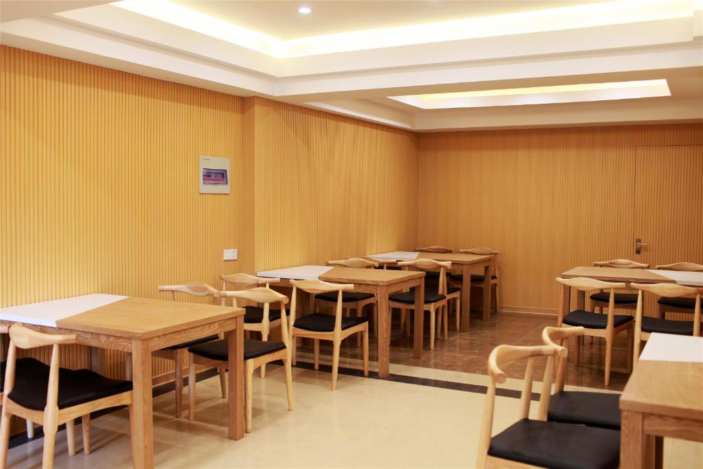 Xincai格林豪泰河南省驻马店市新蔡县月亮湾公园商务酒店的房间里的一排桌子和椅子