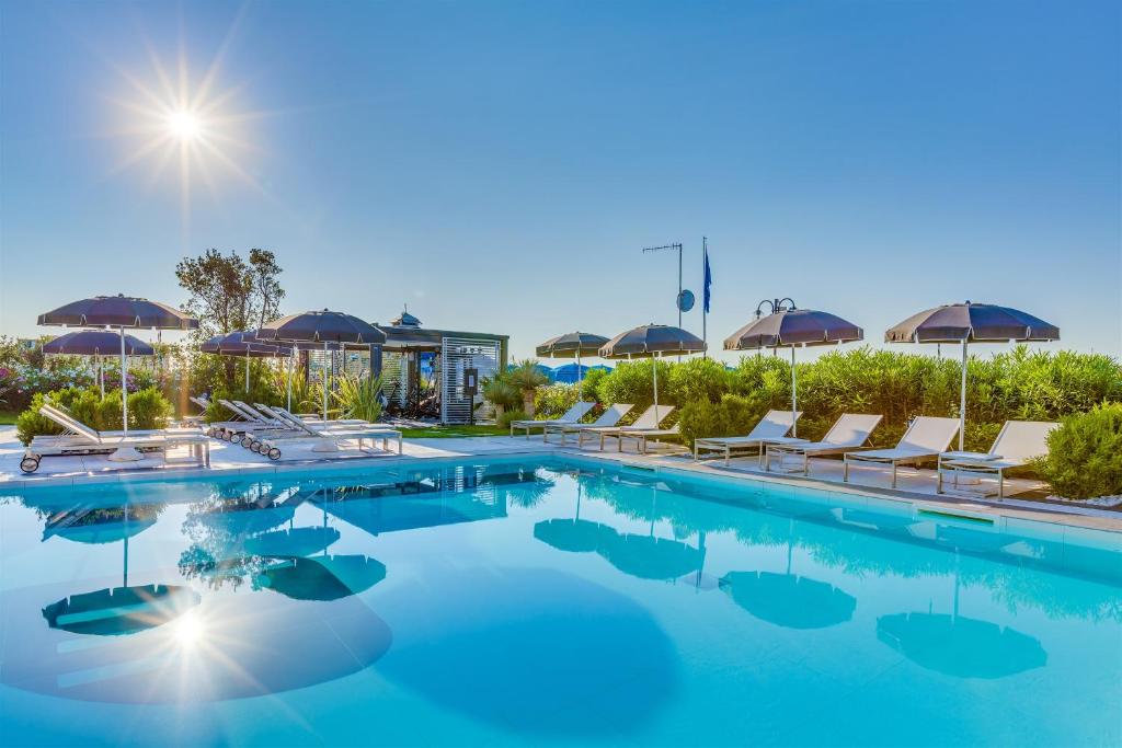 利多迪耶索罗玛丽维尔酒店的游泳池,带椅子和遮阳伞