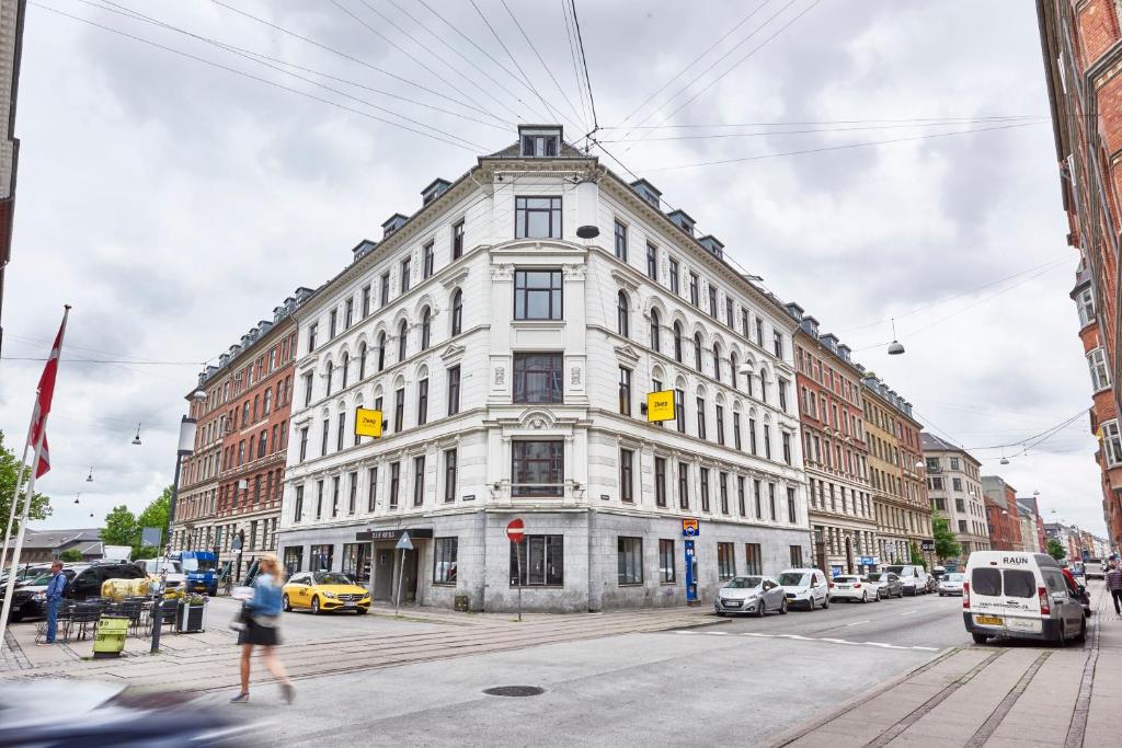 哥本哈根哥本哈根市兹利普酒店的一条有汽车的城市街道上白色的大建筑