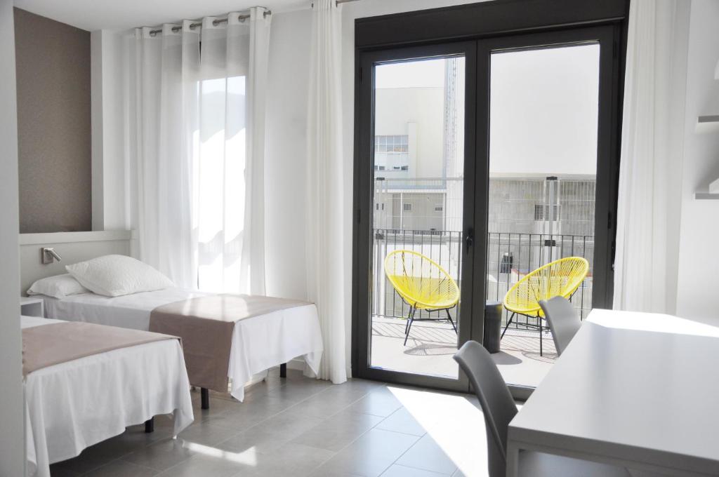 塔拉戈纳Residencia Universitaria Tarragona Mediterrani的酒店客房设有两张床和一个阳台。