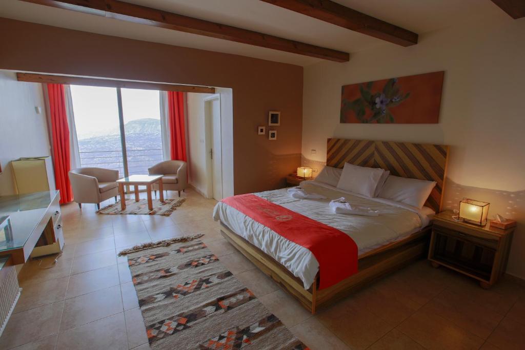 达纳Dana Guesthouse的一间卧室配有一张带红色毯子的床和一张书桌