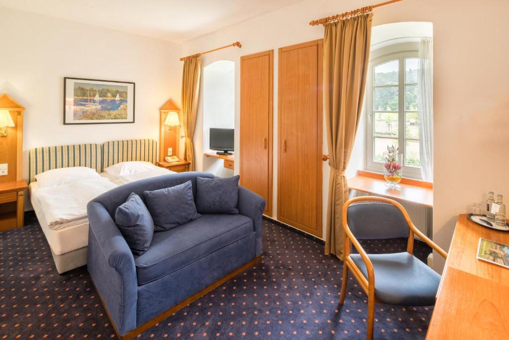 巴特嫩多夫伊斯帕拉德大酒店的酒店客房配有蓝色的沙发和床。