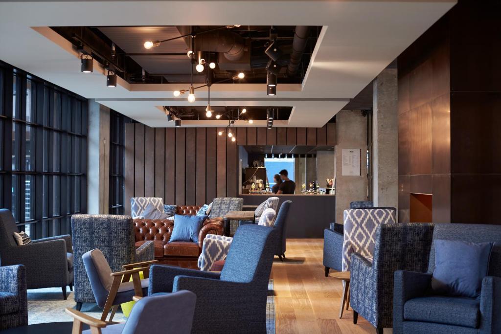 哥本哈根哥本哈根斯迪尔酒店的一间设有蓝色椅子的等候室和一间酒吧
