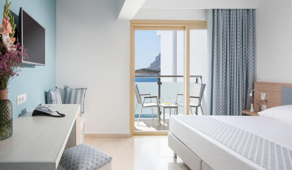 米尔泰Zephyros Hotel的酒店客房设有一张床,享有海景。