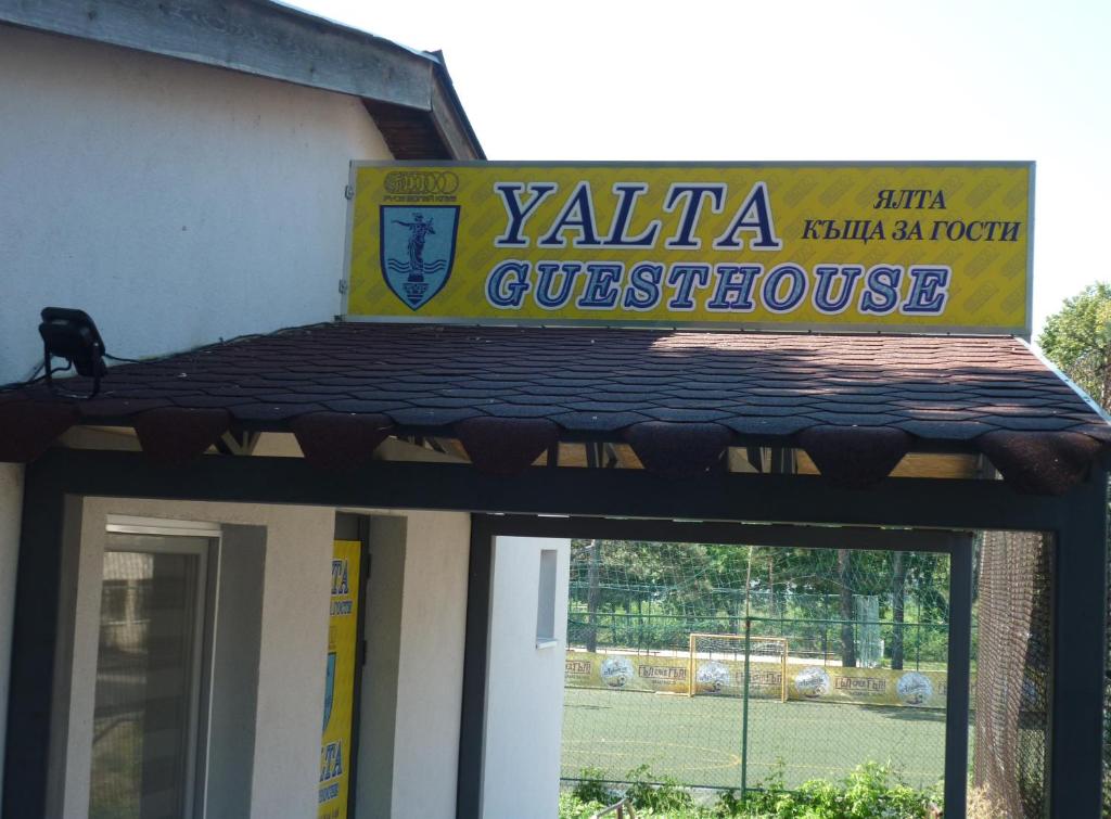 鲁塞YALTA guesthouse的一座带网球场的建筑上的标志