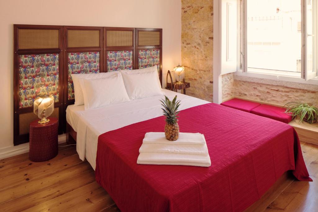 里斯本里斯本客房公寓的一间卧室配有一张带红色毯子的大床
