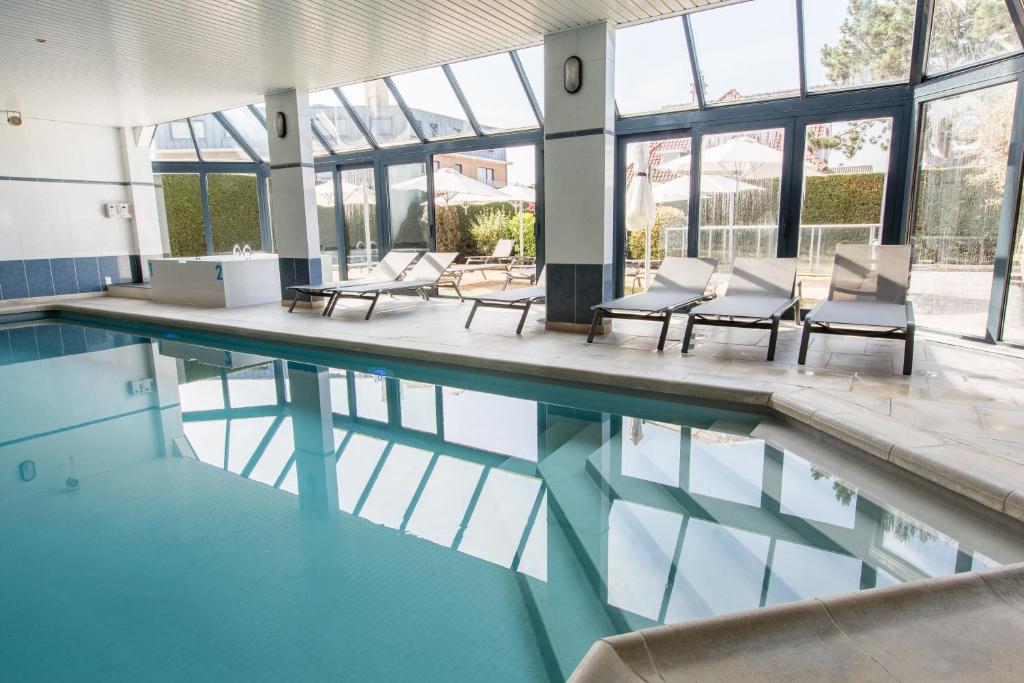 科克赛德阿珀斯多欧夫酒店的游泳池设有桌椅和窗户