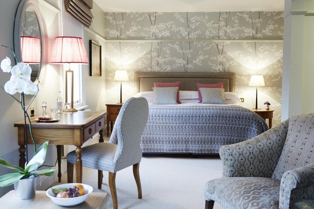赫里福德城堡别墅酒店的卧室配有一张床、一张桌子和椅子