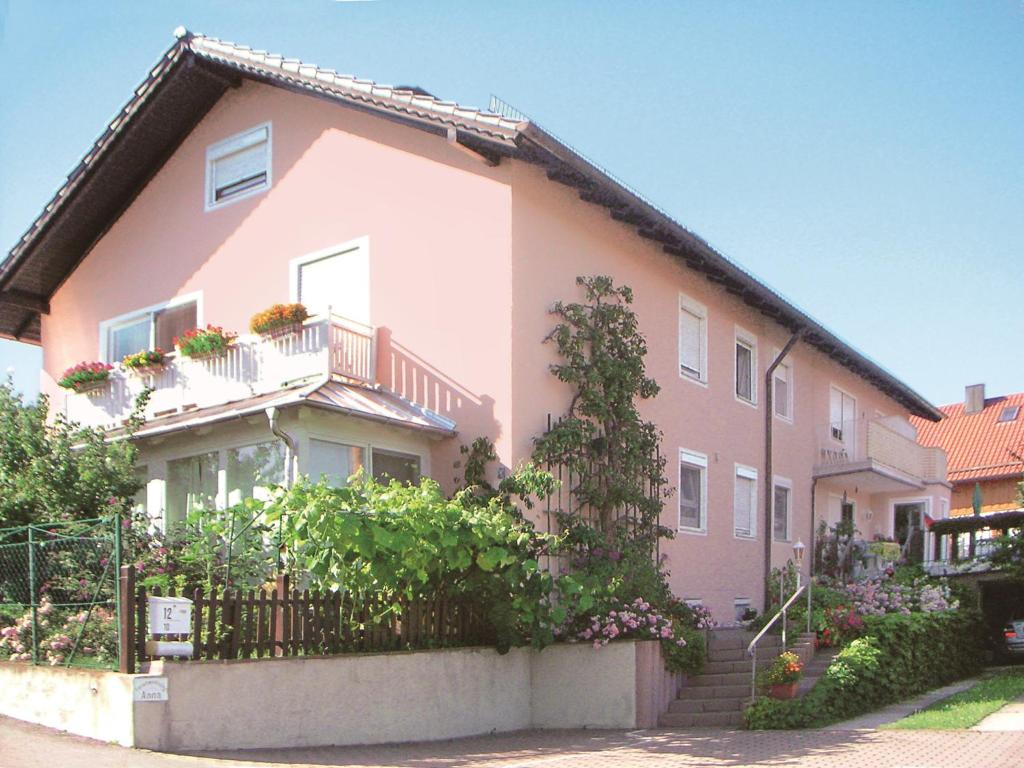 巴特比恩巴赫Ferienwohnungen Anna的粉红色的房子,前面有栅栏