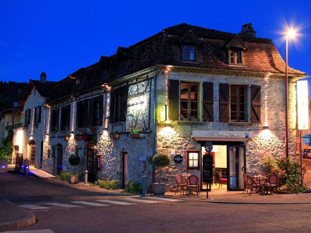 圣塞雷Le Victor Hugo - Hôtel et Restaurant - Logis Hôtels的街上一座带灯的古老石头建筑