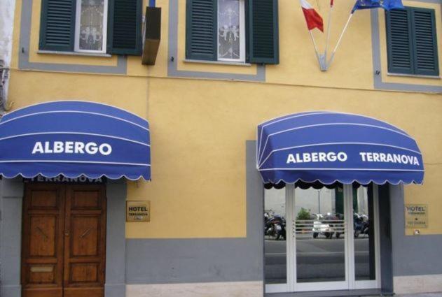 比萨泰拉诺瓦酒店的建筑的侧面有蓝色遮阳篷