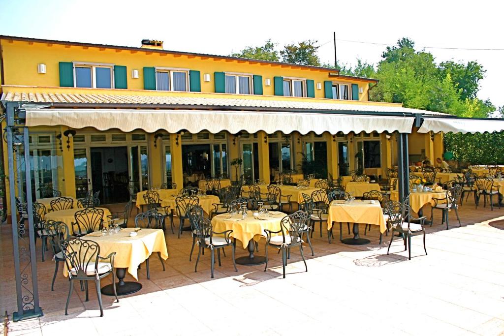 卡瓦伊翁韦罗内塞甜蜜生活酒店的大楼前设有桌椅的餐厅