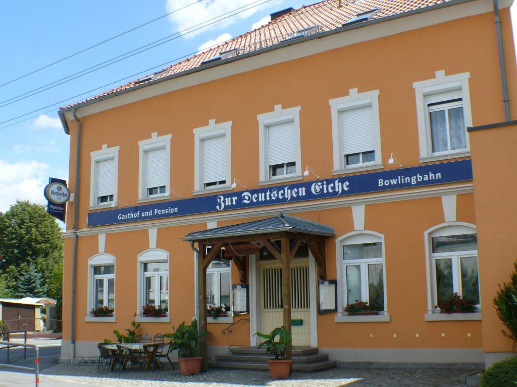 大舍瑙Zur deutschen Eiche的一座橙色的建筑,上面有蓝色的标志