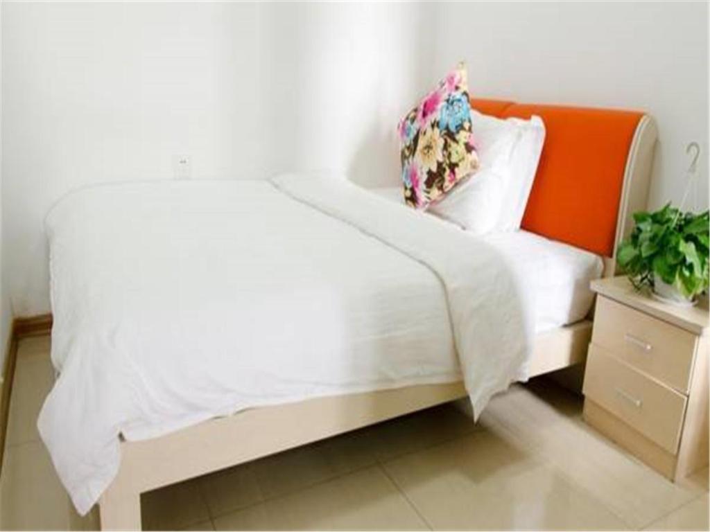 西安西安海伦公寓的一间卧室配有一张白色床和橙色床头板