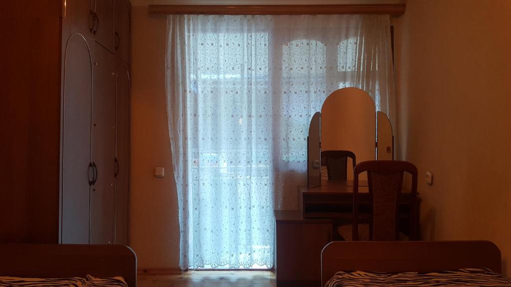 苏呼米Частный сектор的配有白色窗帘和镜子的窗户