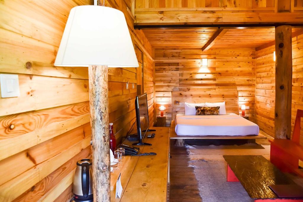 ShogiSuro Treehouse Resort的小木屋内的卧室,配有一张床和一盏灯