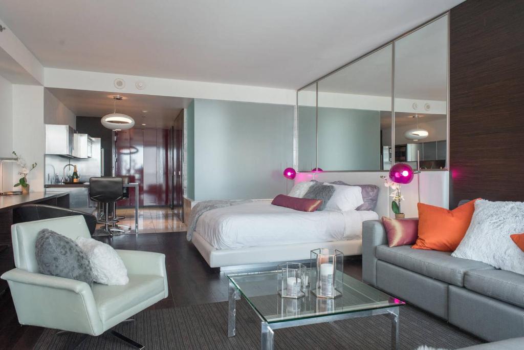 拉斯维加斯棕榈广场豪华套房酒店的一间卧室配有一张床、一张沙发和一张桌子