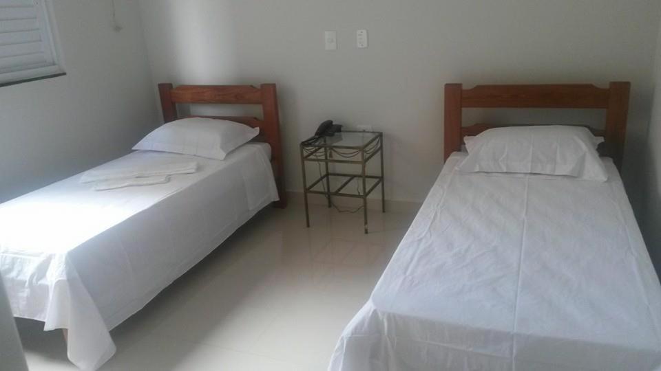 Aparecida do TaboadoArym Hotel的两张睡床彼此相邻,位于一个房间里