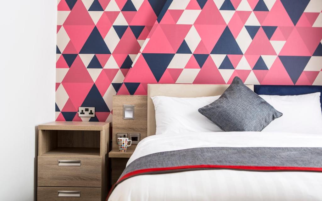 爱丁堡爱丁堡城市酒店的卧室设有粉红色和蓝色几何墙
