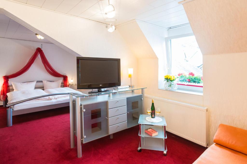 埃迪格尔-埃莱尔苏木鲁文默赛罗曼蒂克酒店的一间卧室设有一张带电视和窗户的床。