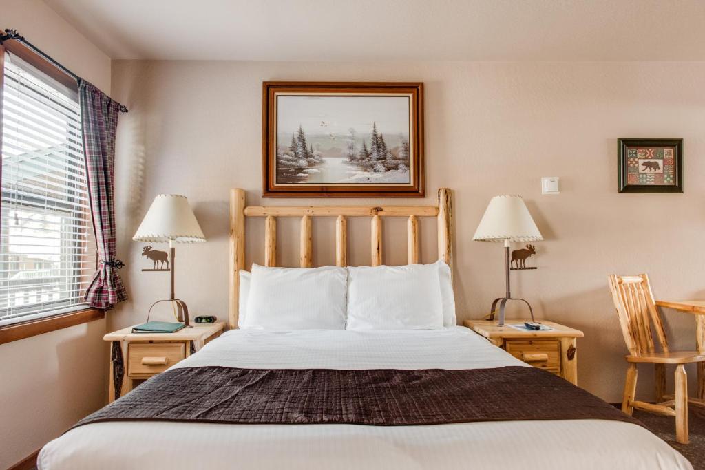 塔霍维斯塔Franciscan Lodge的一间卧室配有一张床、两张桌子和两盏灯。