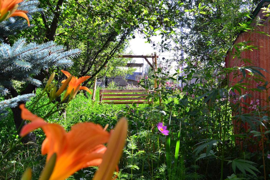 塞凡Serik & Geora Guesthouse的花园内种有花草,后方设有长凳