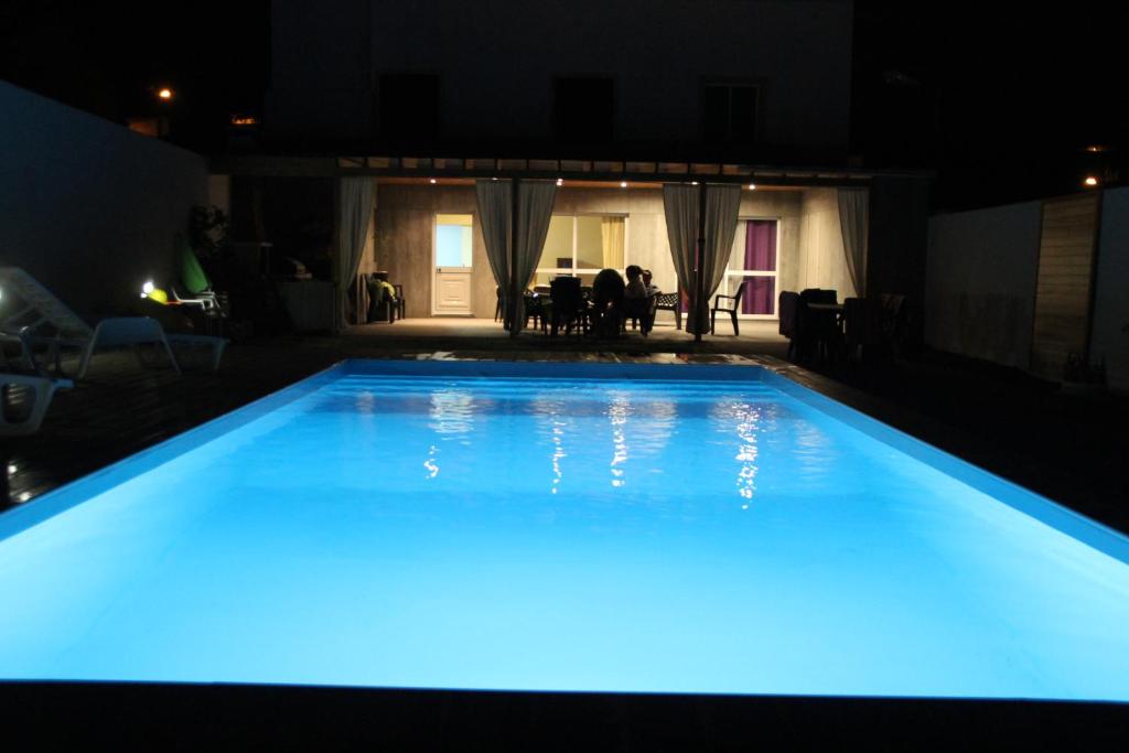 Rabo de PeixeCasa do Sossego - Guesthouse的一座拥有蓝色灯光的大型游泳池