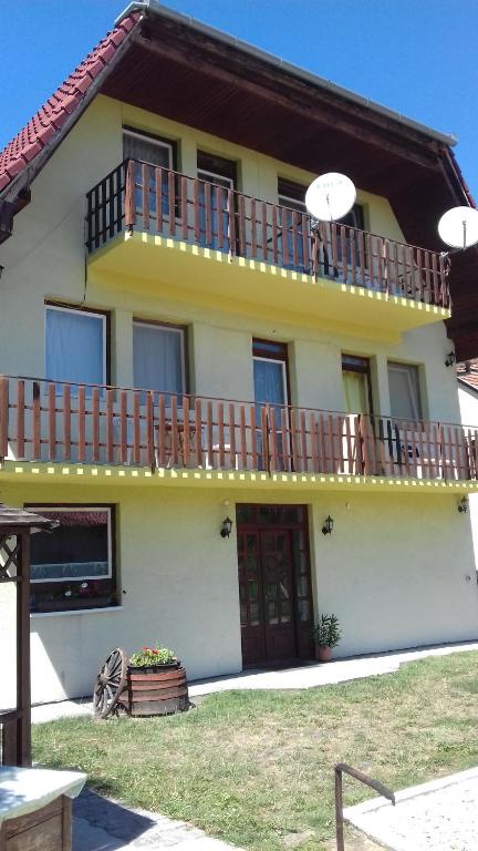 鲍洛通费尼韦什Apartmanhaz Balatonfenyves的黄色和白色的房子设有阳台