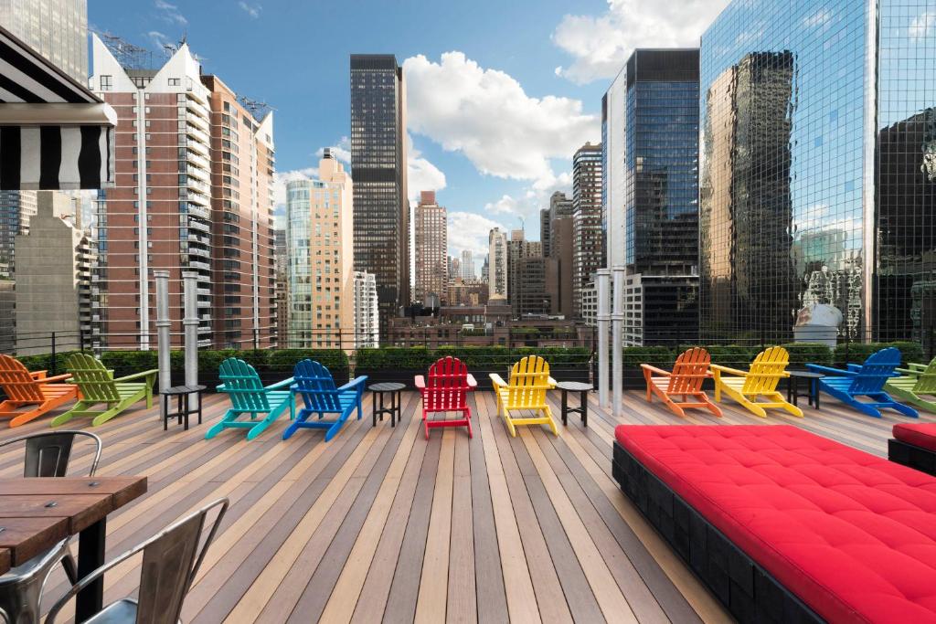 纽约珀德51酒店的城市里带五颜六色椅子和桌子的甲板