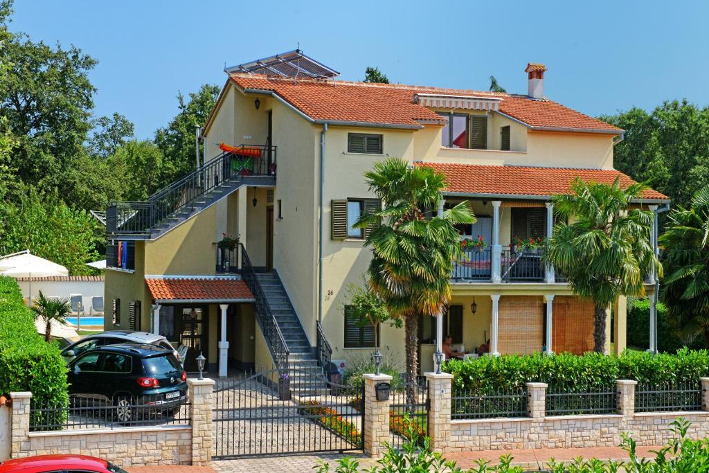 RošiniApartments Pilic的前面有停车位的房子