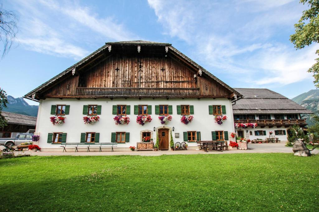圣沃尔夫冈Weinbachbauer - Urlaub am Bauernhof的一座白色的大建筑,设有木屋顶