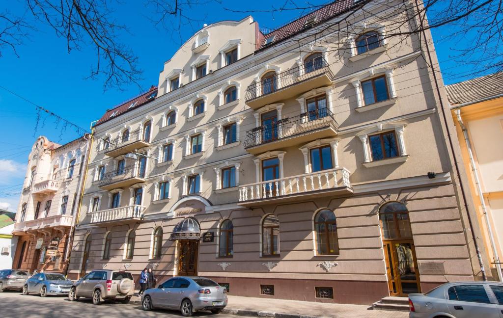 伊万诺-弗兰科夫斯克斯坦尼斯拉维夫酒店的一座大型建筑,前面有汽车停放