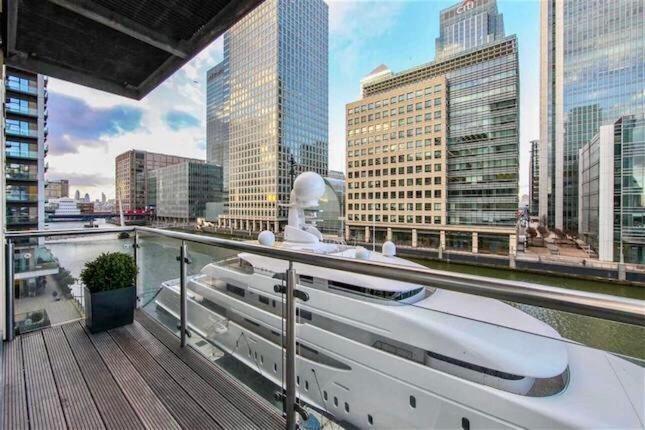 伦敦NY-LON Corporate Apartments的河上建有建筑物的船只阳台