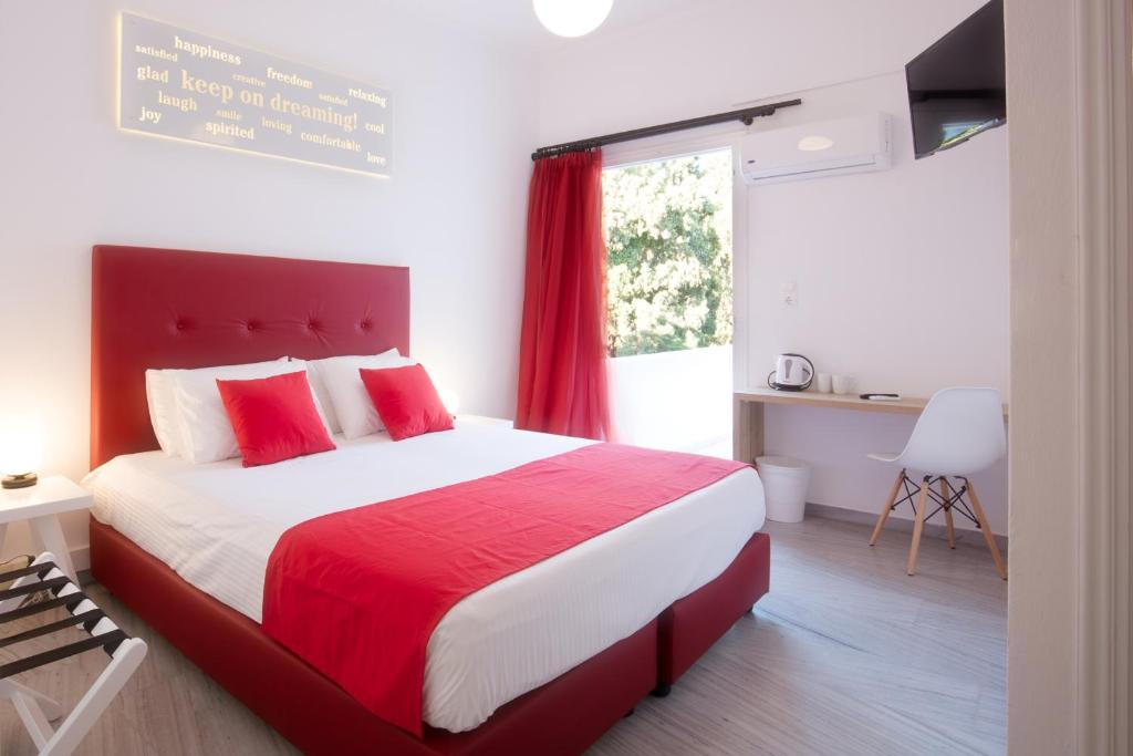 帕罗奇亚Acqua Vatos Paros Hotel的卧室设有红色和白色的床和窗户。