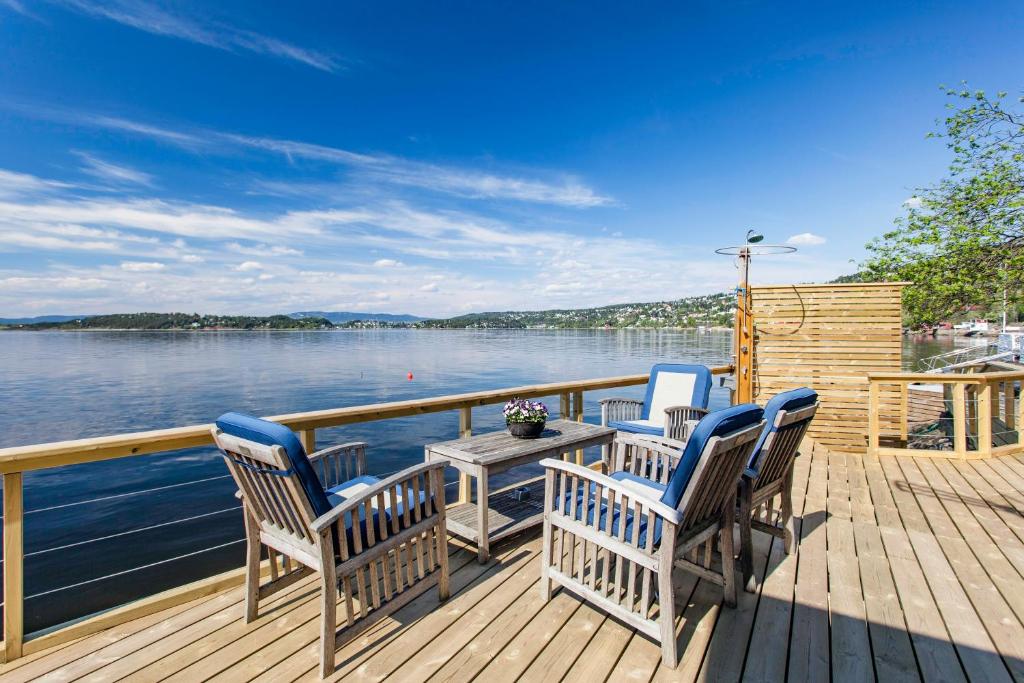 奥斯陆Beach house in Oslo的甲板上配有三把椅子和一张桌子