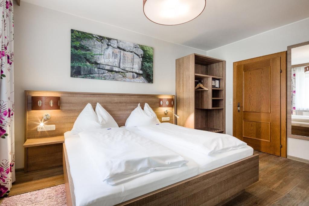 Obermühl吉尔林格酒店的一间卧室配有一张带白色床单的大床