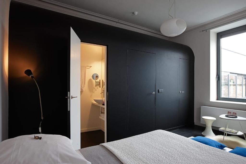 布鲁日布鲁日之夜住宿加早餐旅馆的一间卧室设有黑色墙壁和一张床