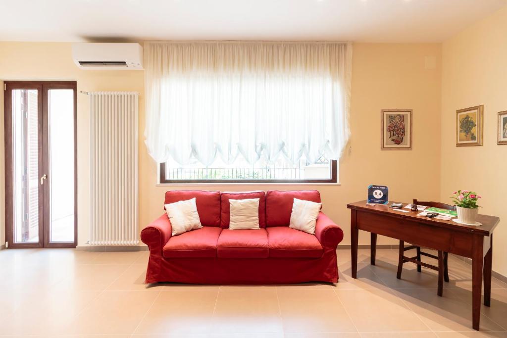 孔韦尔萨诺Corte dei Nobili的客厅里的一个红色沙发,带有窗户