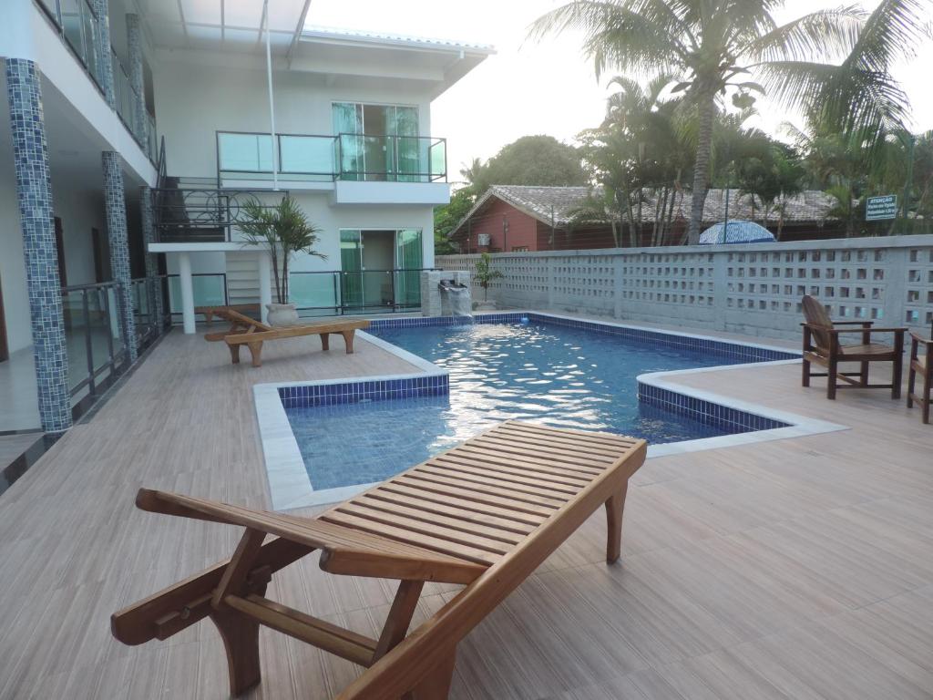 塞古罗港Areia do Atlantico Hotel的阳台的游泳池,长凳
