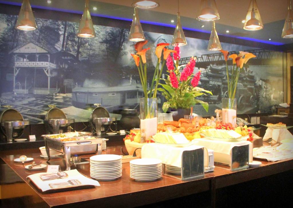 坤甸坤甸基尼酒店的自助餐,餐桌上摆放着盘子和鲜花