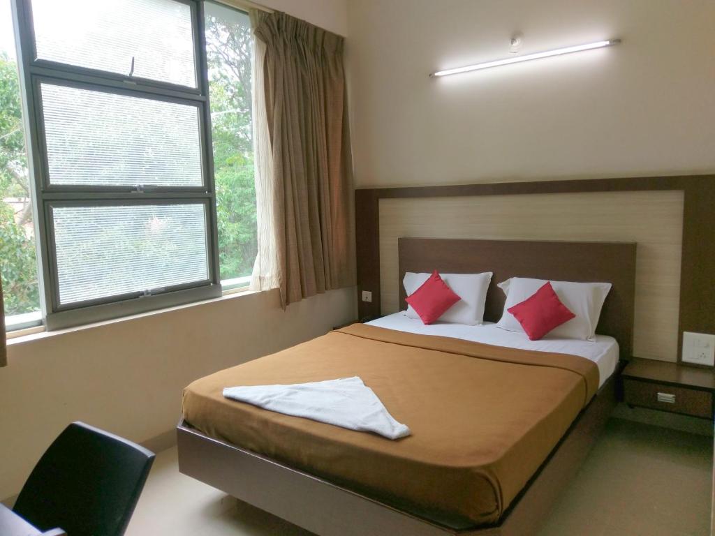 迈索尔Banyan Tree Comforts Mysore的一间卧室配有红色枕头的床