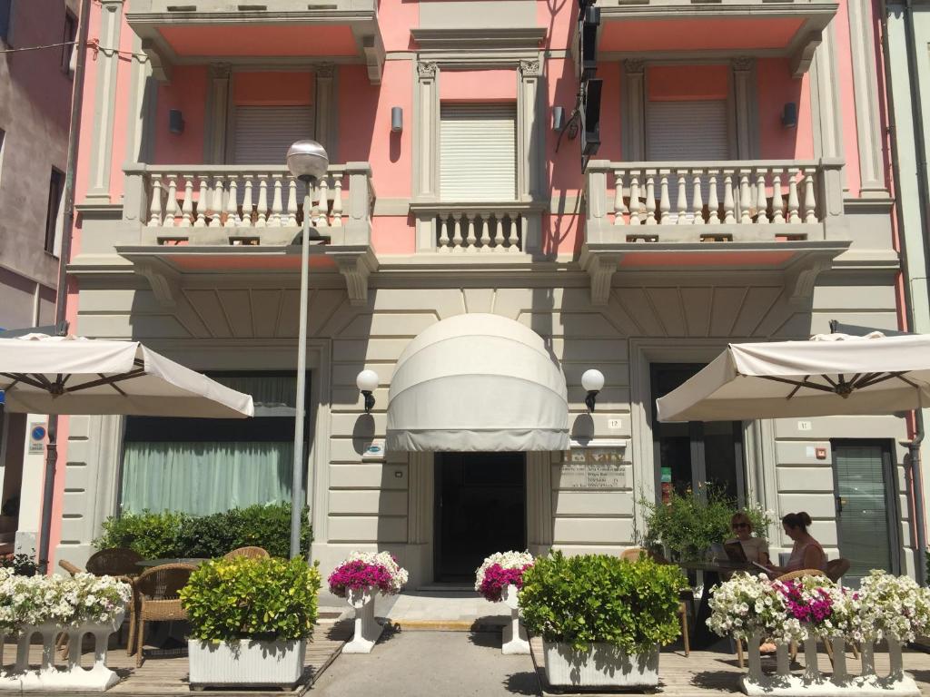 维亚雷焦凯蒂酒店的一座建筑前面有鲜花和遮阳伞