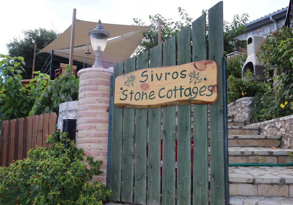 SívrosSivros Stone Cottages的商店用标牌的栅栏
