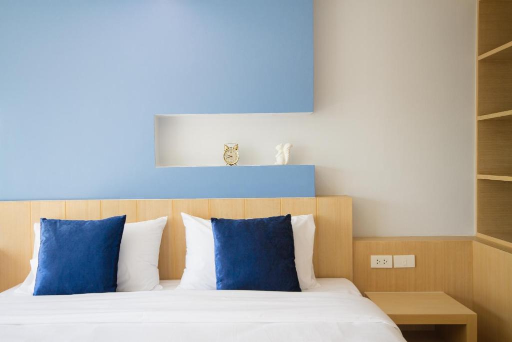 罗勇魅力公寓的一间卧室配有一张带蓝色枕头的床